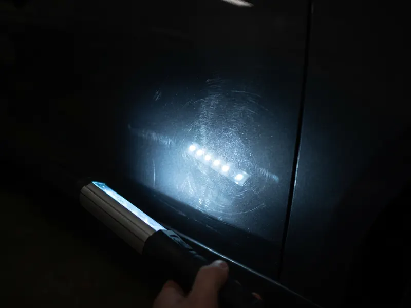 Swirl marks visible under inspection light, before shot — Tint Express paint correction